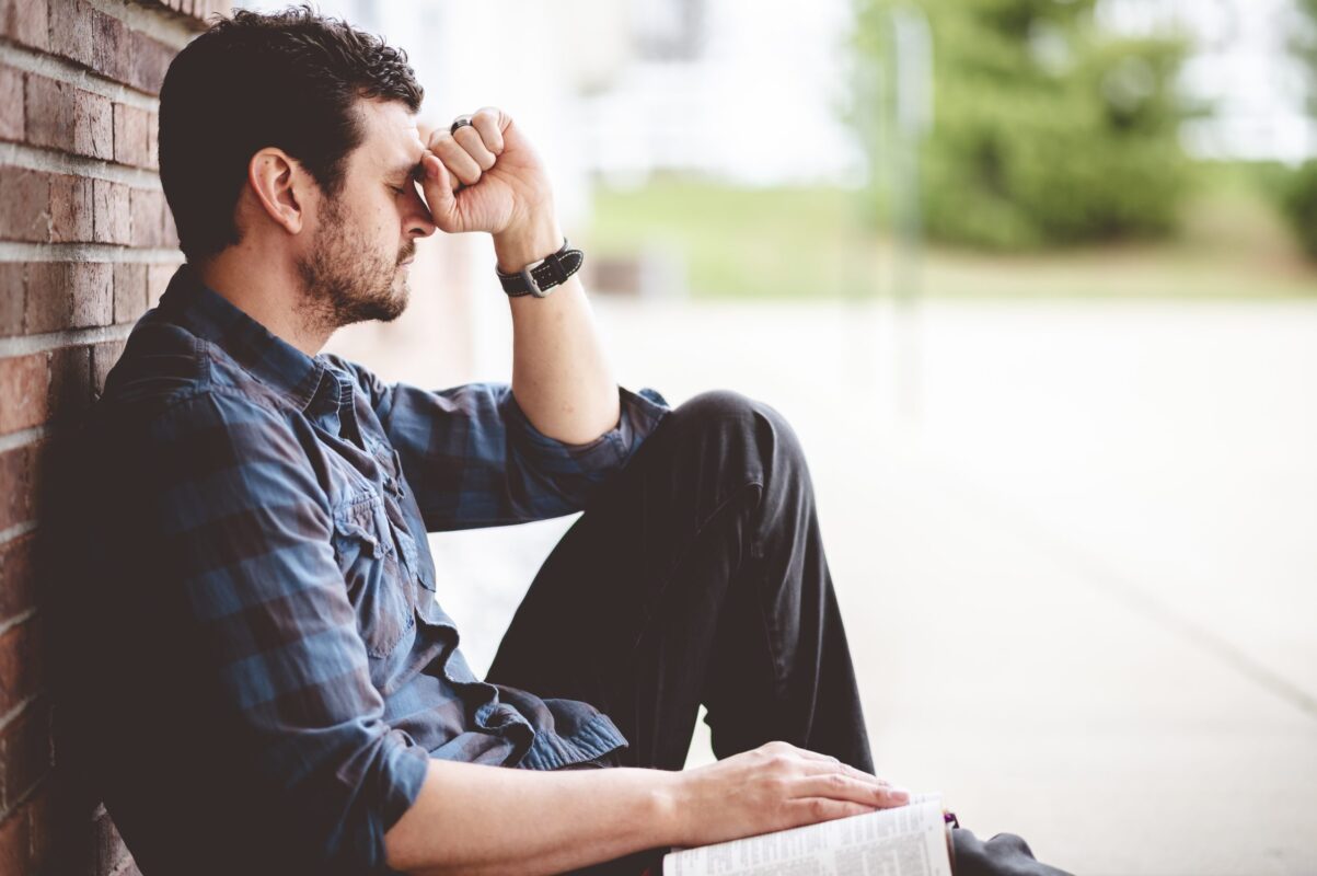 Adult man sitting on pavement concept image of mania vs hypomania