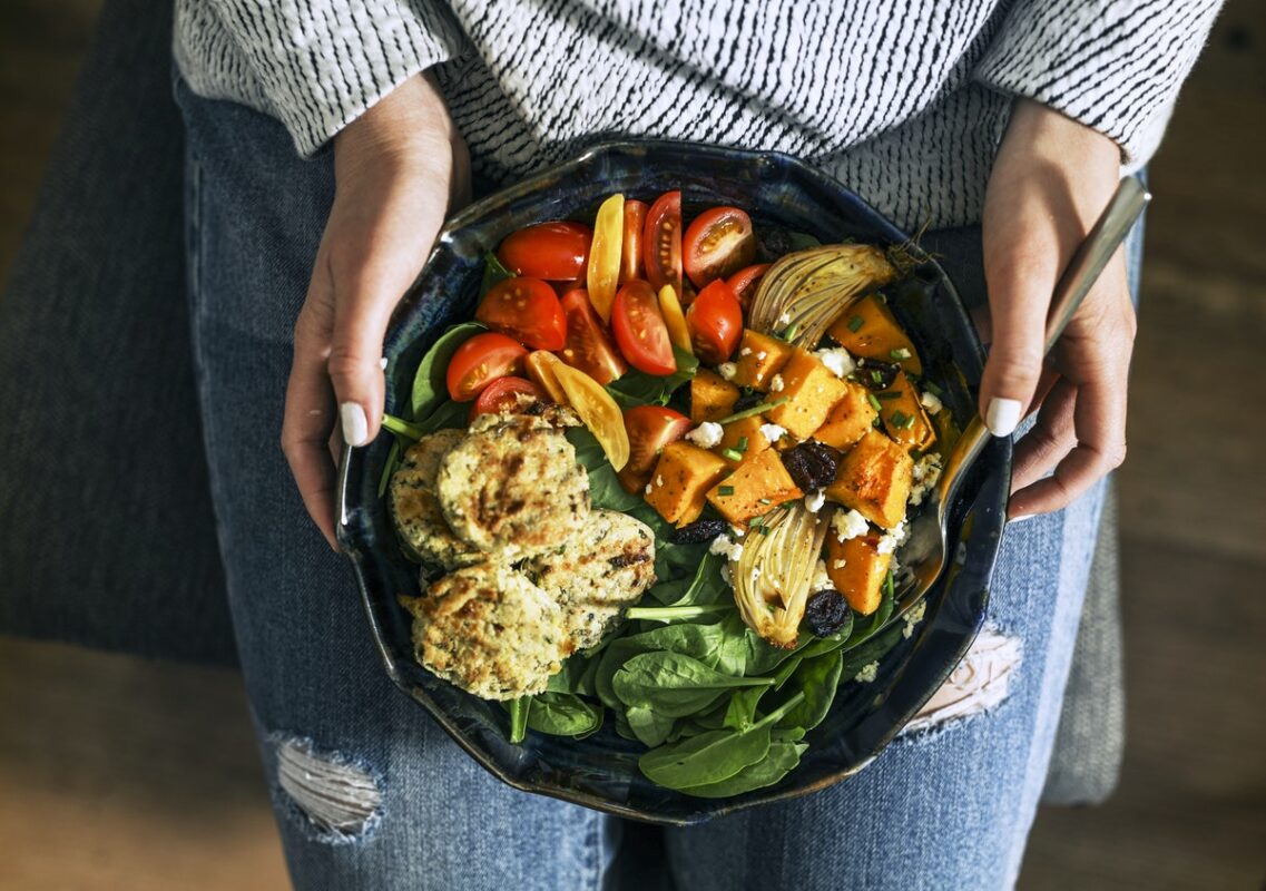 woman holding bowl of vegetables