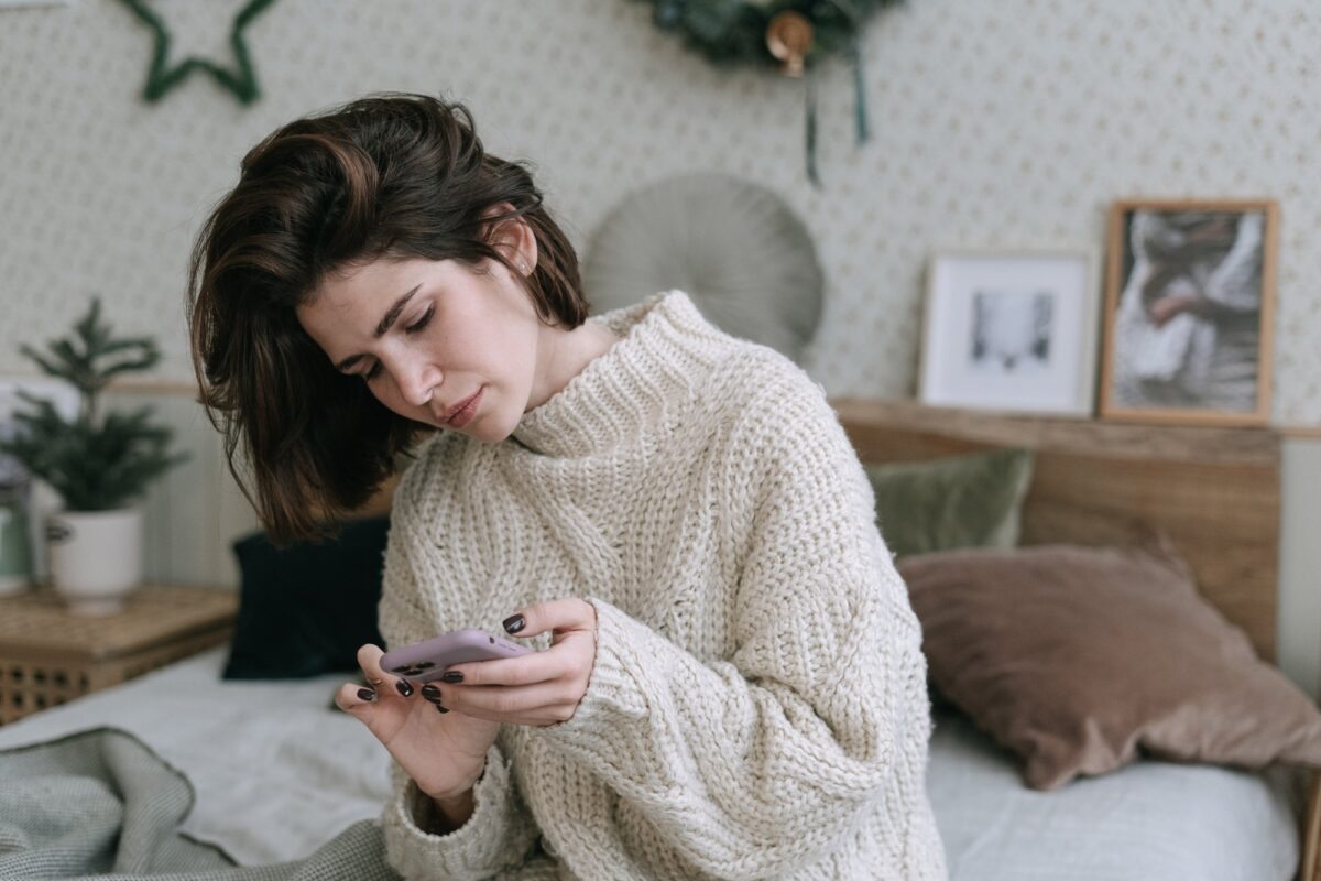 |family at the festive table|woman checking her cellphone in a christmas decorated room